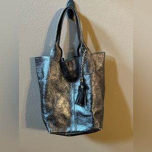 Metallic gray leather handbag with zipper pouch and tassel.